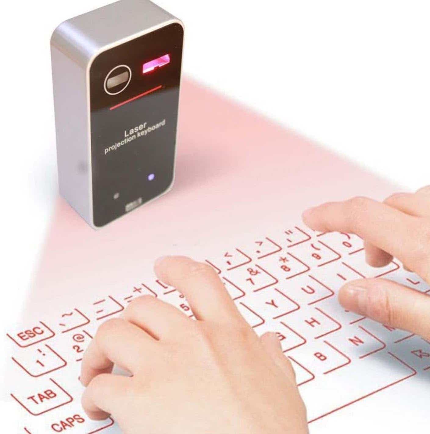 Two hands operate a wireless laser projected keyboard.