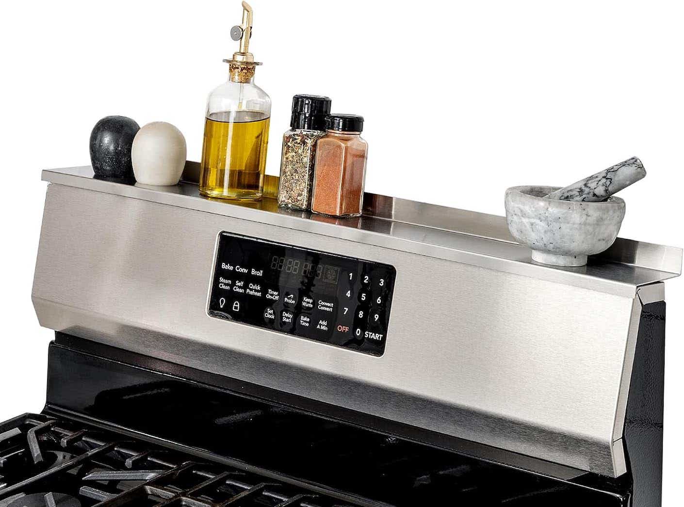 A metal magnetic shelf is placed on top of a metal stove.