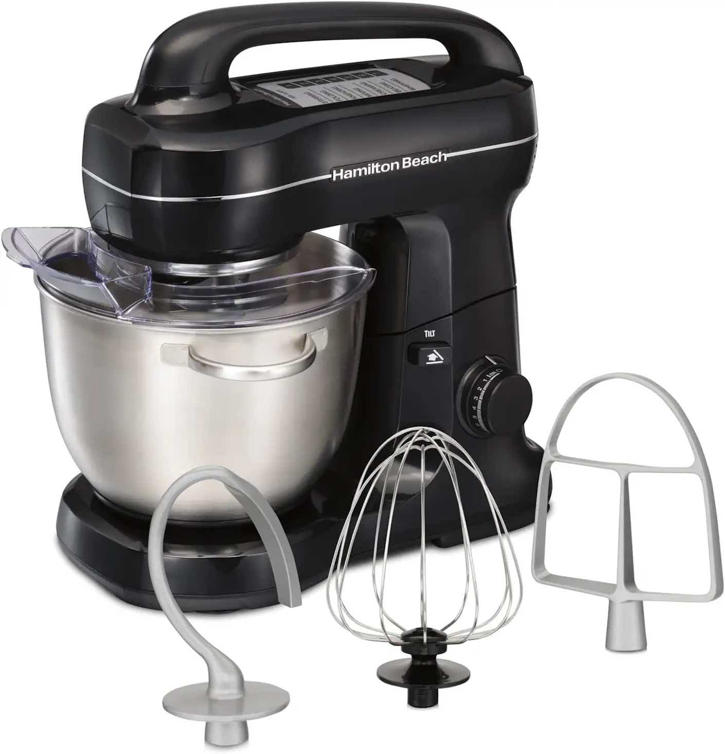 A black stand mixer stands behind a trio of attachments: a white dough hook, a white flat paddle, and a metal whisk.