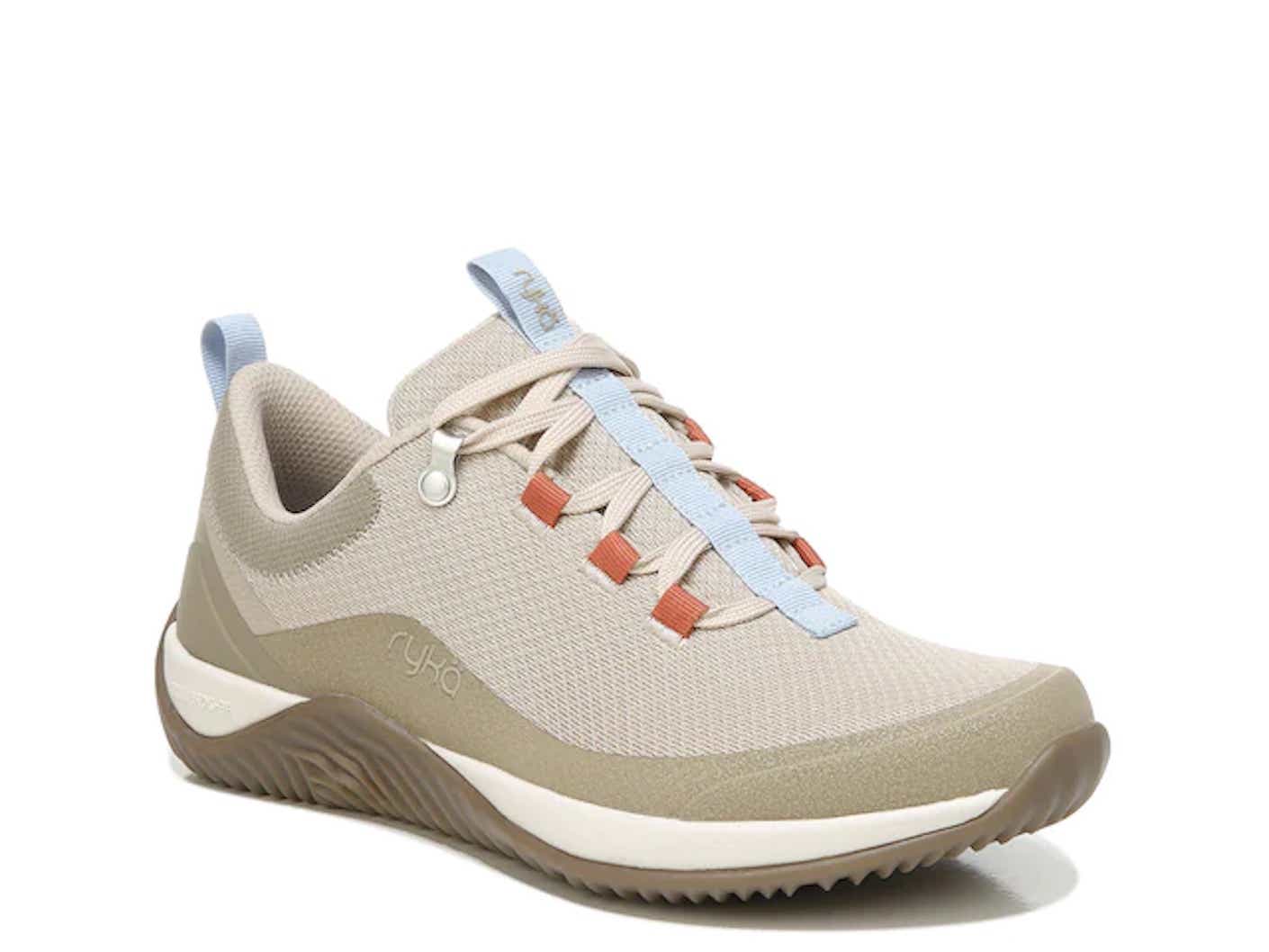 A taupe knit sneaker with a blue and red tongue is in front of a white background.