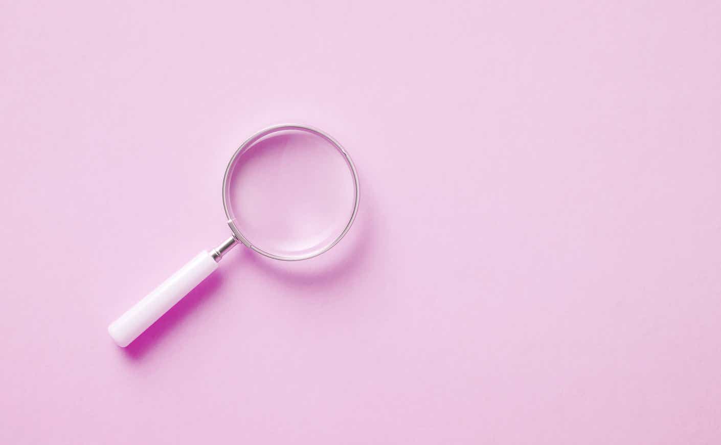 Magnifying glass on pink background