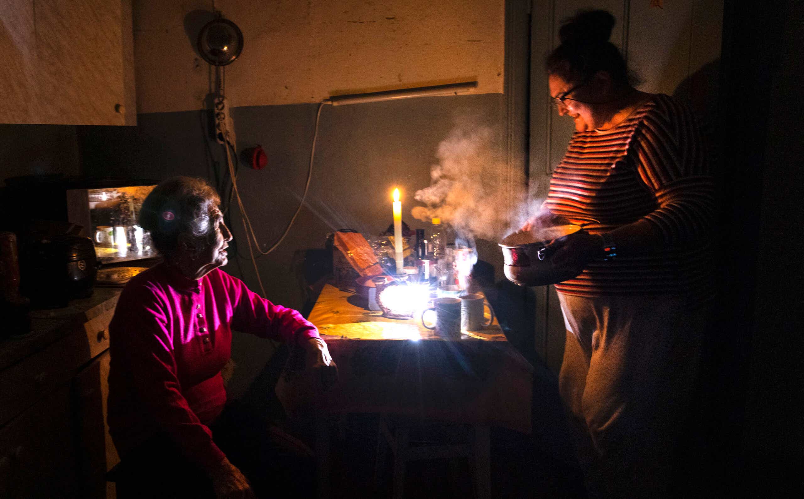 A Ukrainian mother and daughter make tea during the Kyiv power outage