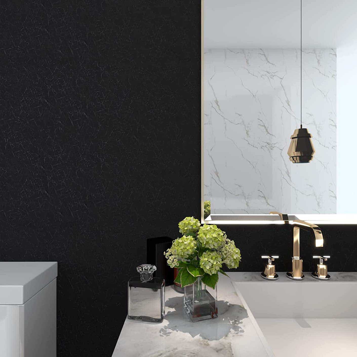 A white marble and ceramic kitchen island with brass accents is contrasted with a wall covered in distressed black silk wallpaper.