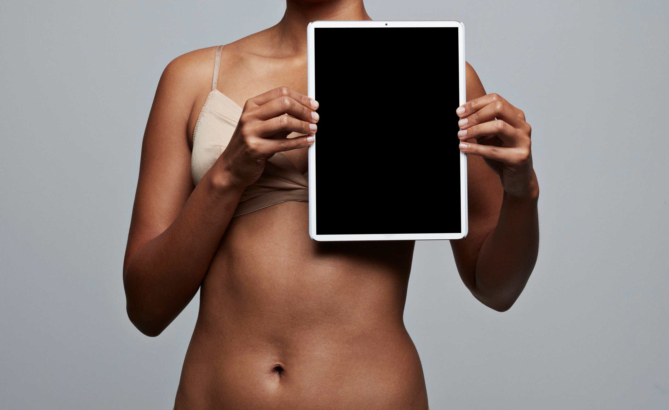 woman holding tablet in front of her chest