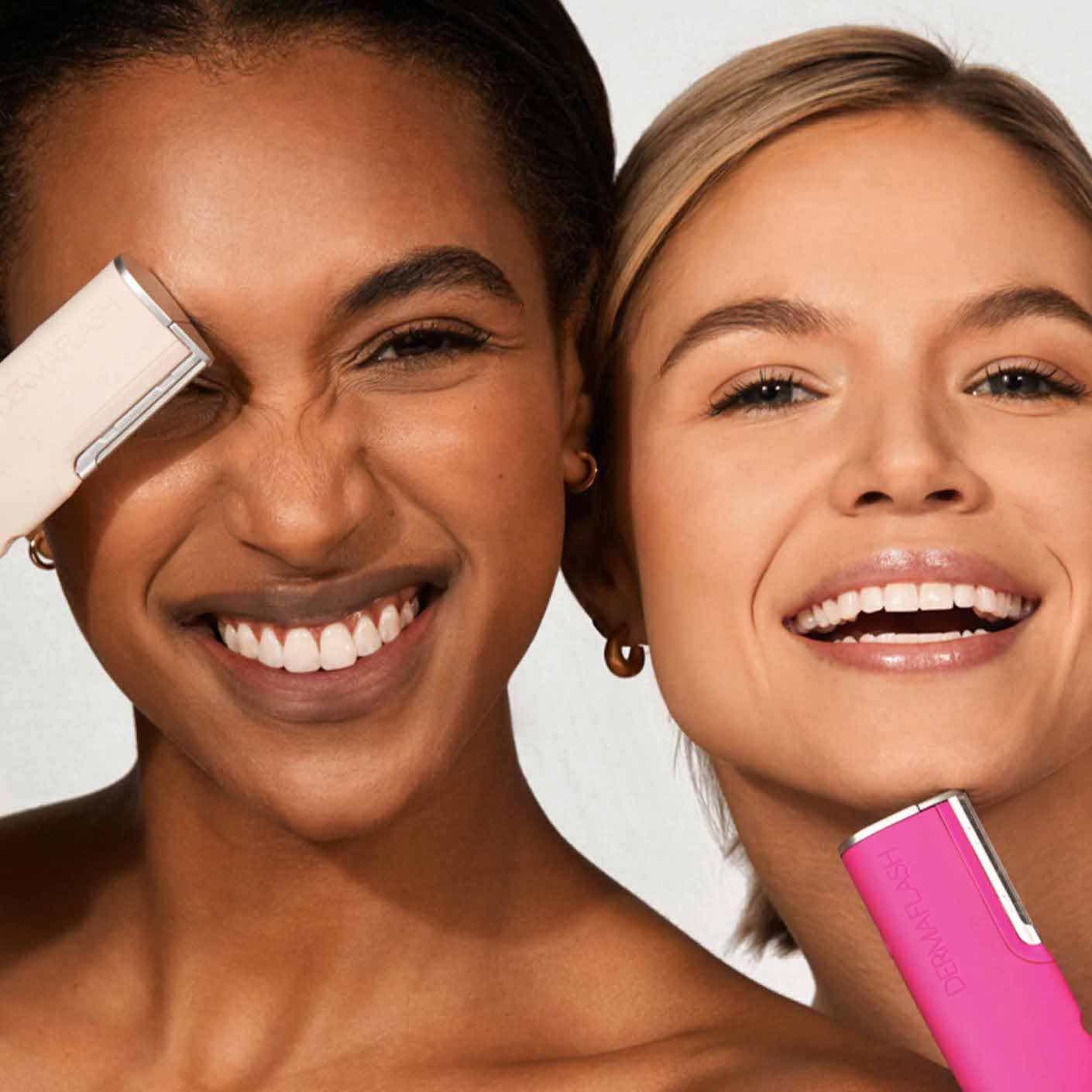 Two women smile and pose with their dermaflash tools.