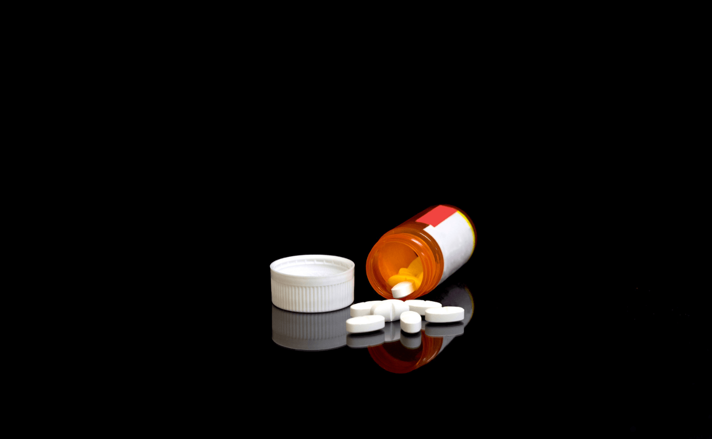 a bottle of pills on a black background