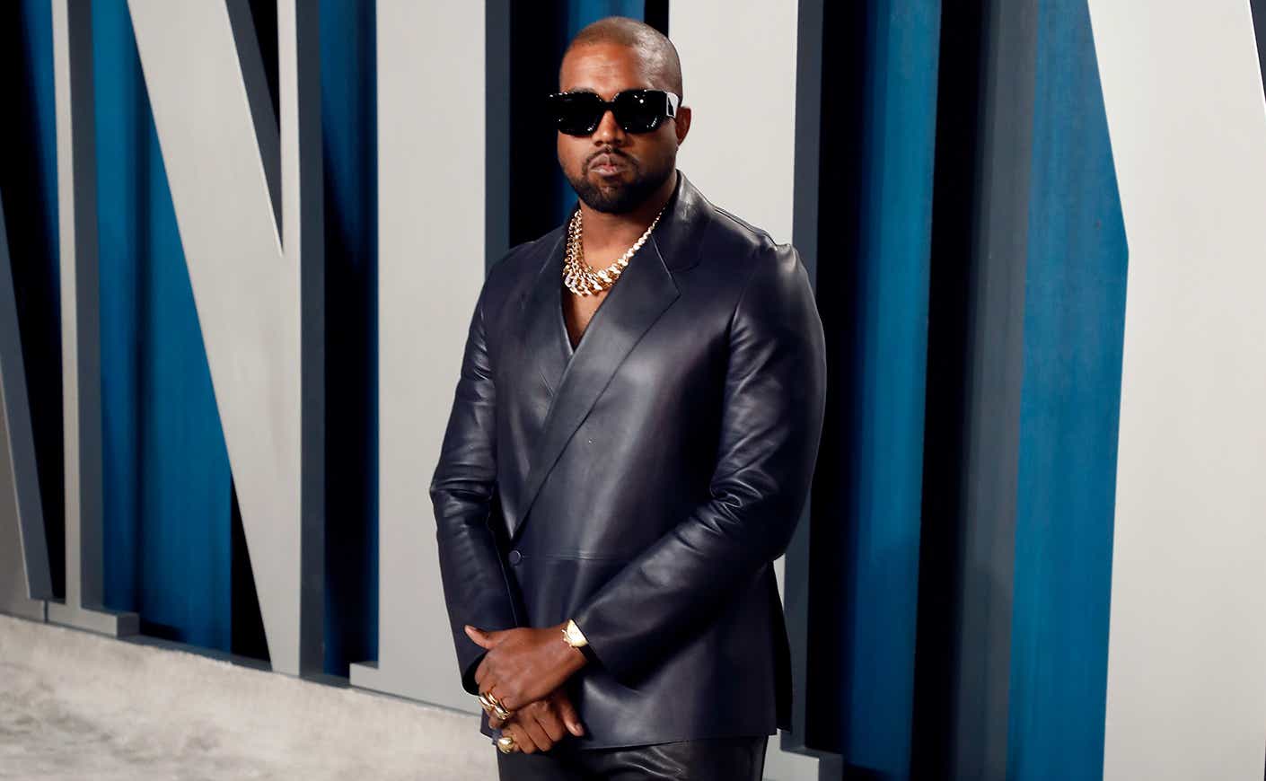 Kanye West stands at attention at the Vanity Fair afterparty for the Oscars