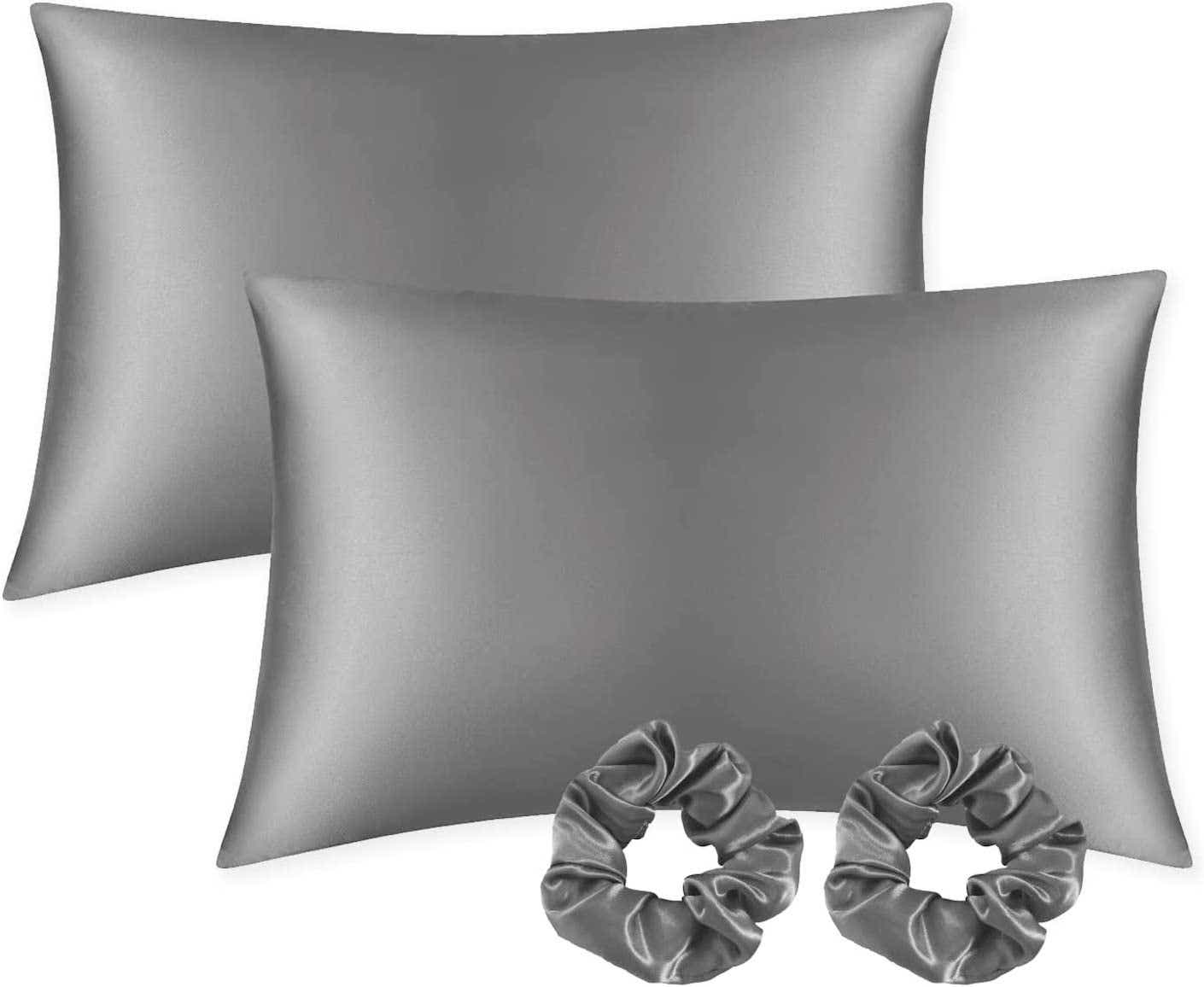 Two silver satin pillowcases stand alongside matching silver satin scrunchies.
