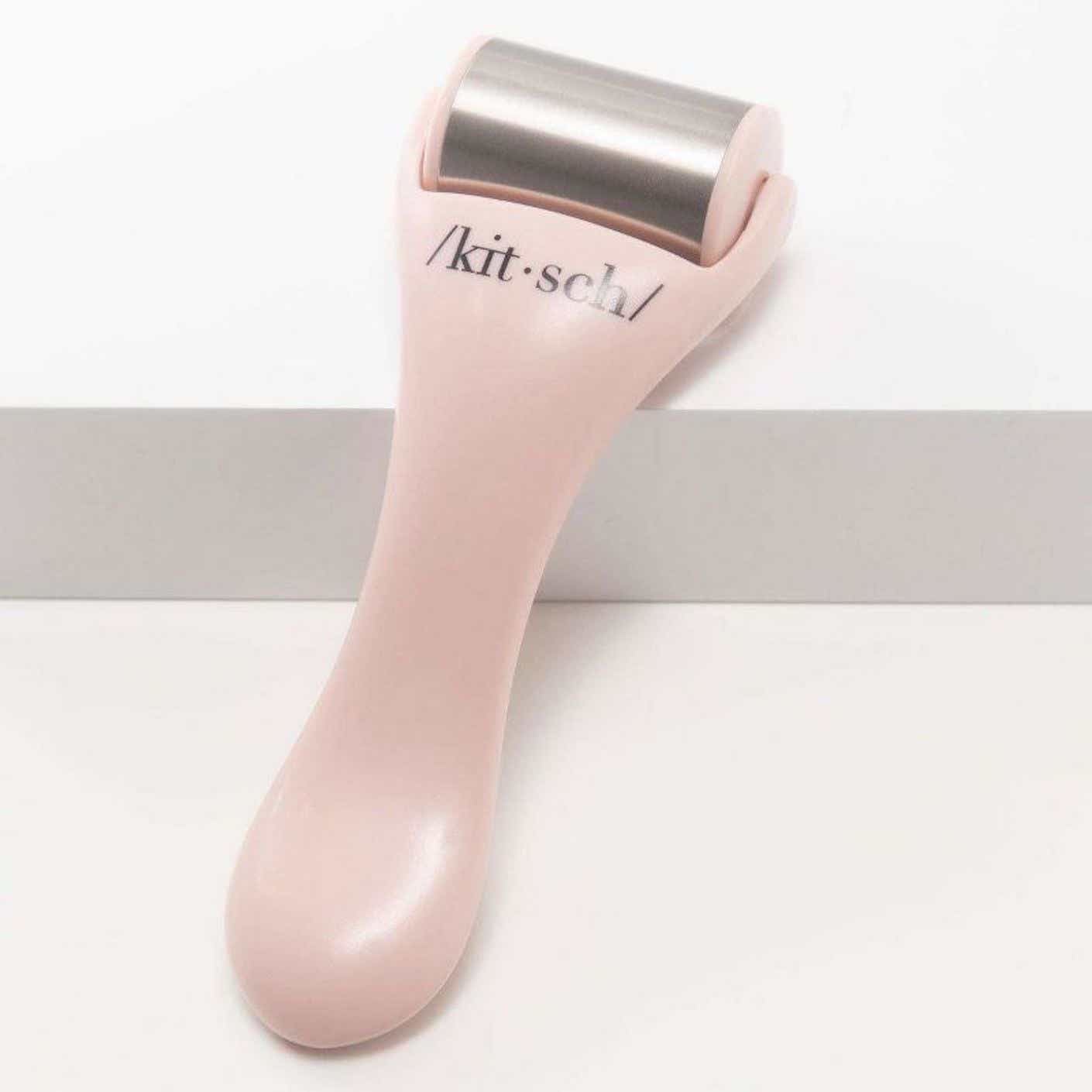 A picture of a light pink plastic ice roller with a metal head.