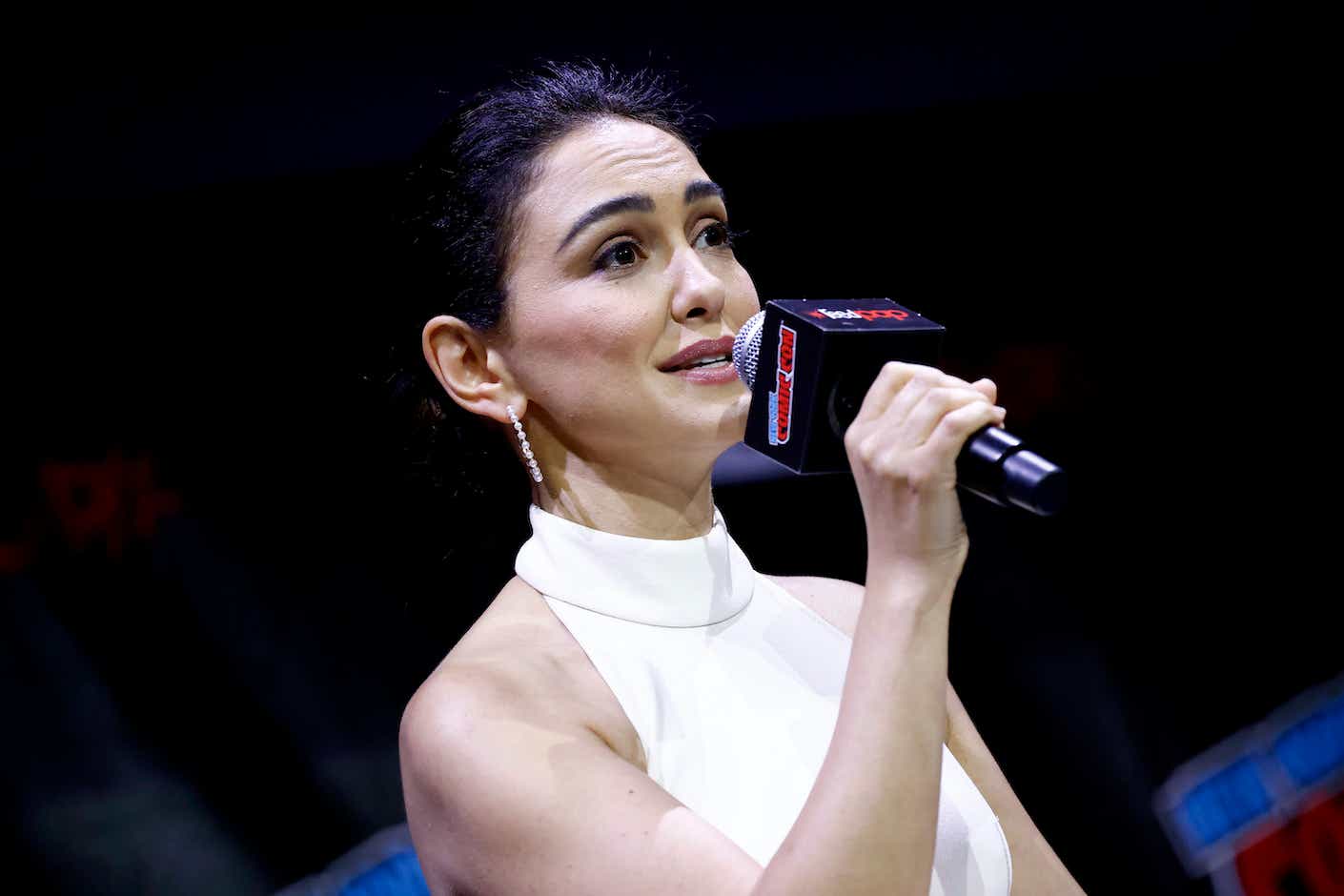 Nazanin Boniadi speaks solemnly into a microphone while onstage.