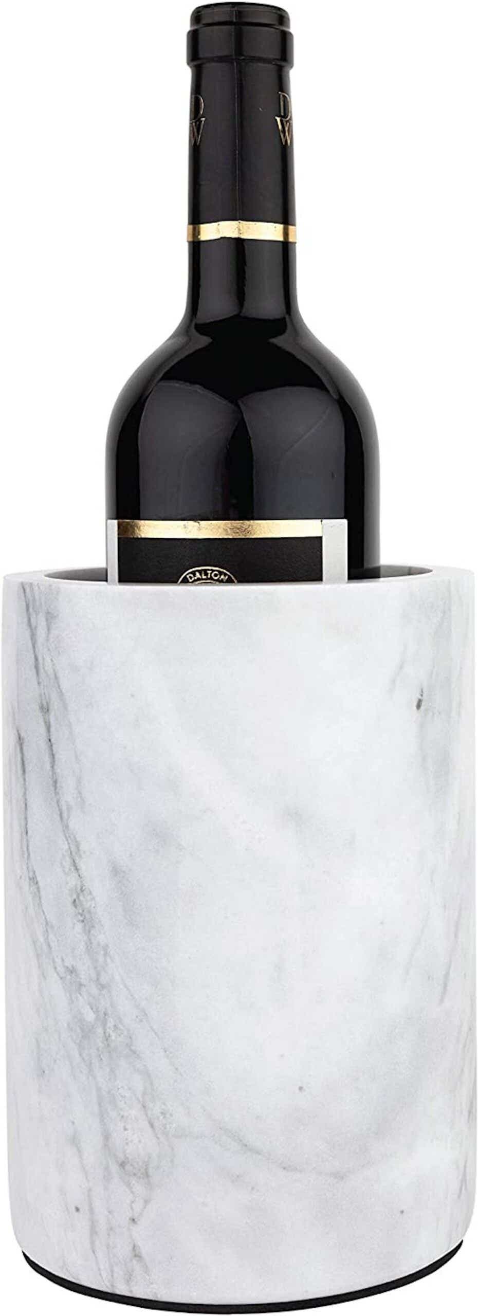 A bottle of wine stands in a cylindrical white marble bucket.