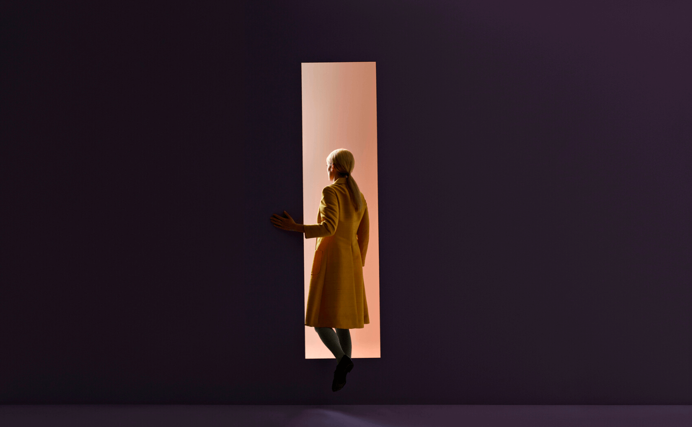 woman walking out of darkness into doorway
