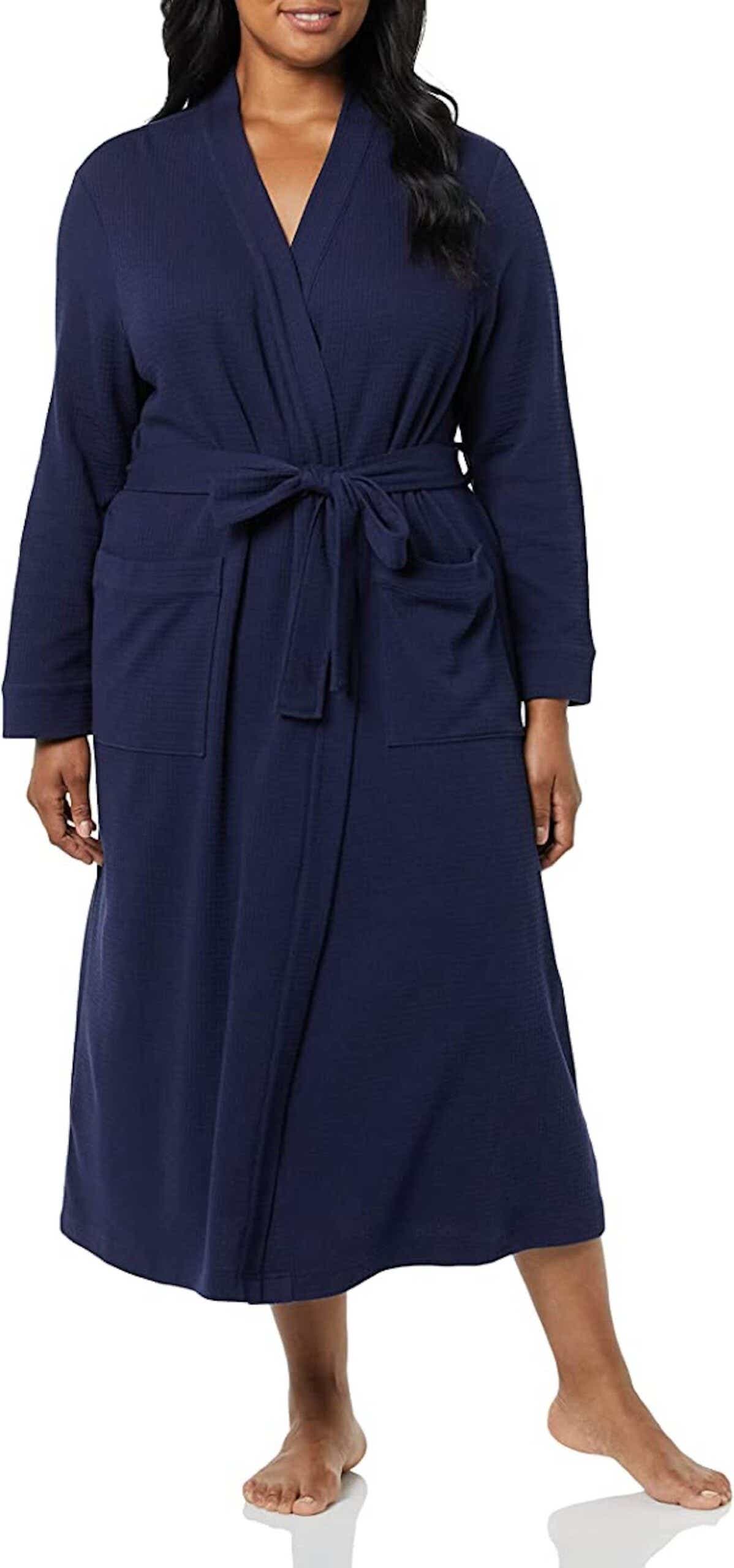 A woman wears a shin-length, navy blue waffle knit robe.