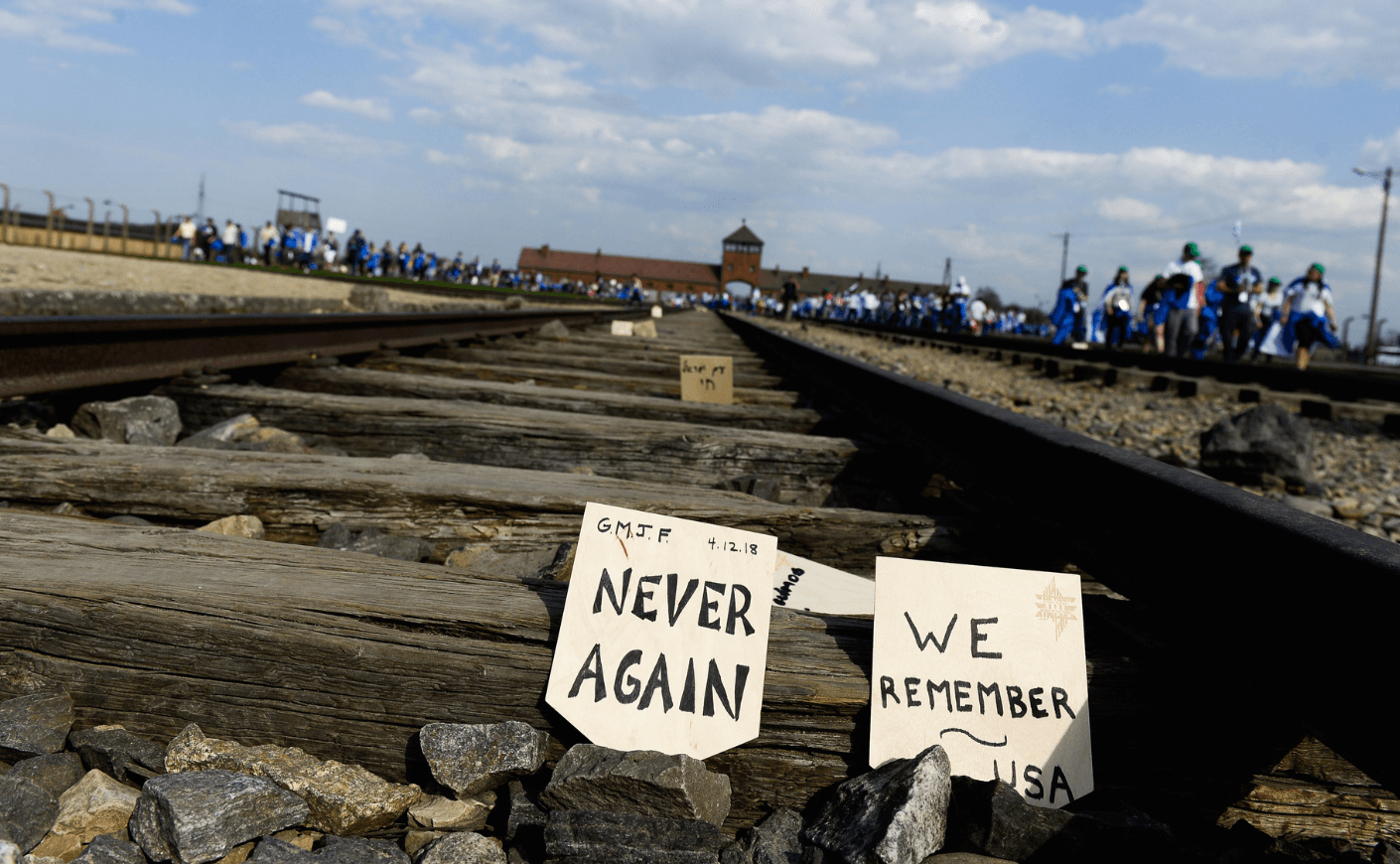a "Never Again" sign on a railroad track