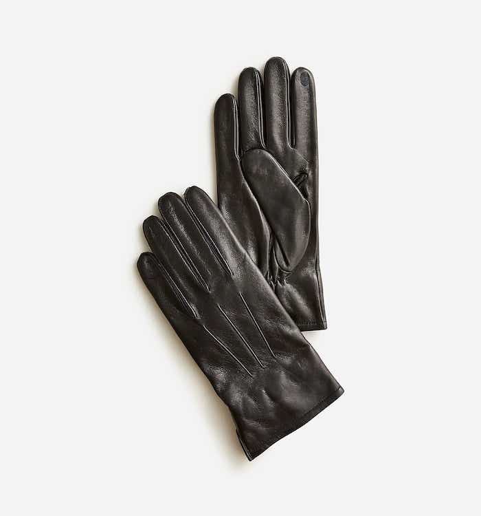 A pair of black gloves lie a top of one another.