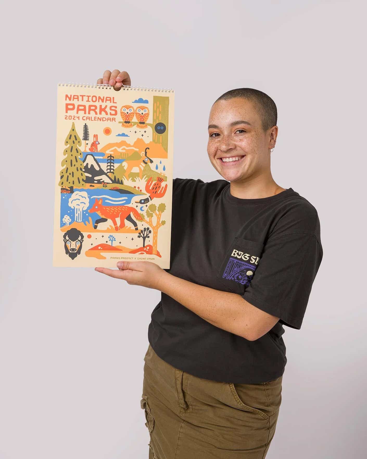 a smiing person holds up a calendar