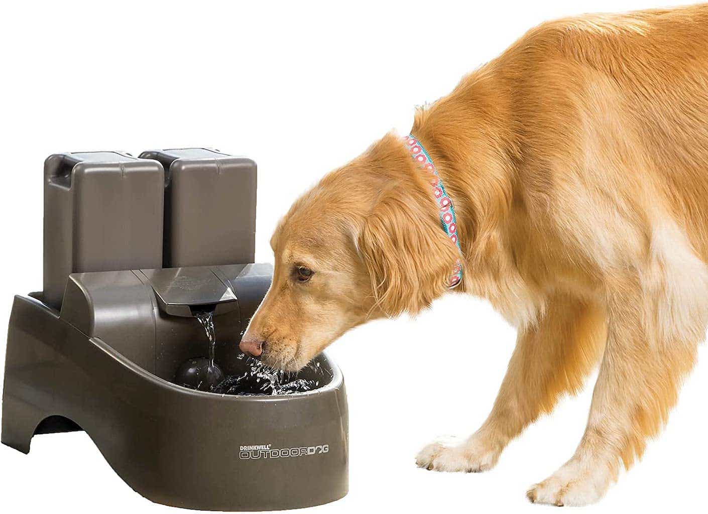 A golden retriever dips its head into a large, plastic, brown fountain.