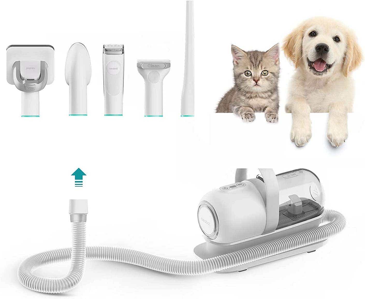 A cat and dog stand next to a white pet vacuum cleaner with five attachment heads.