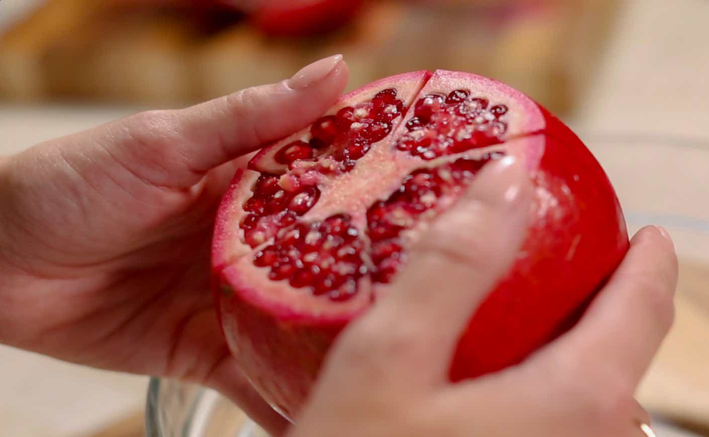 Close up on hands holding a pomegranate