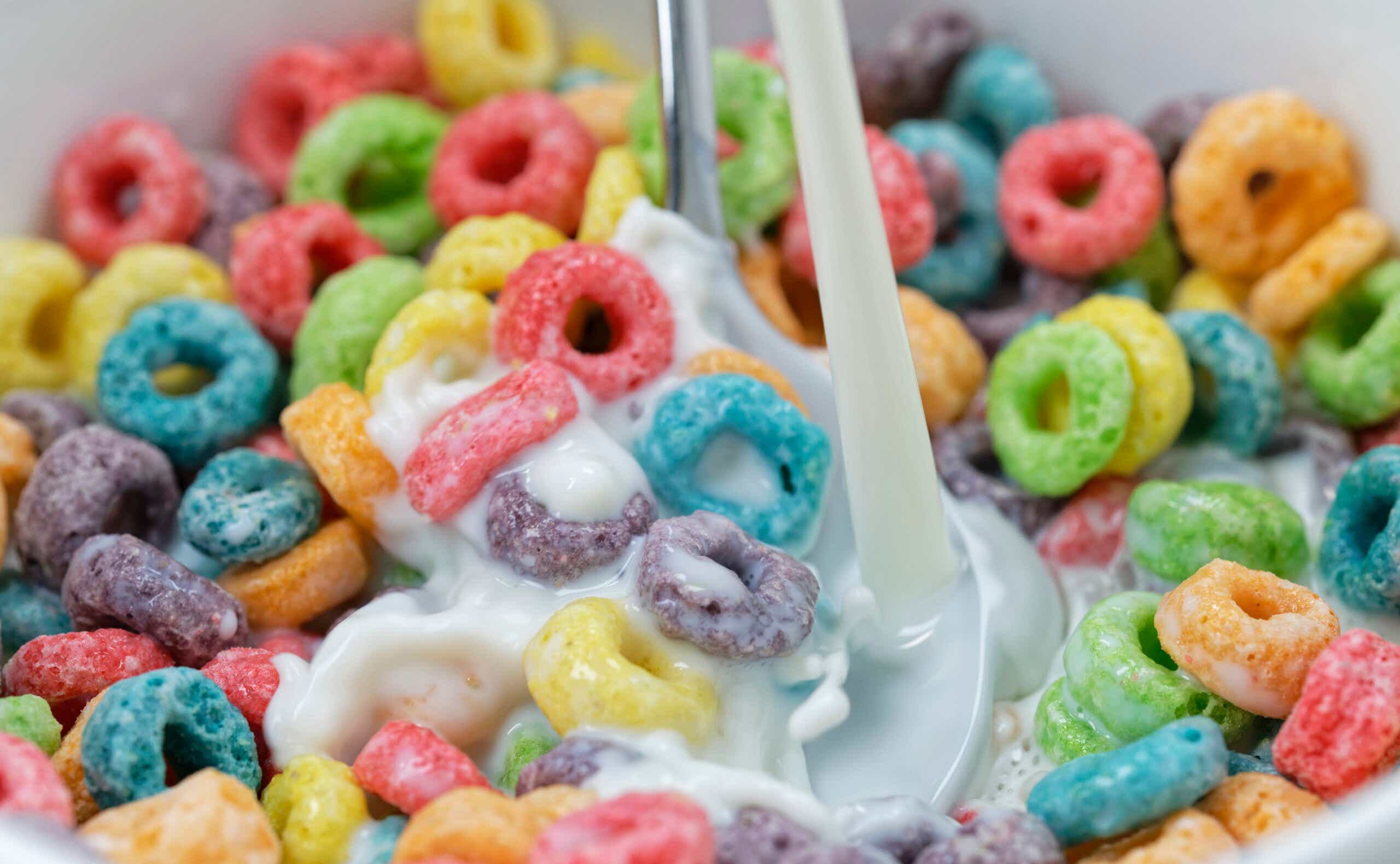 Milk being poured into a bowl of colorful fruit cereal