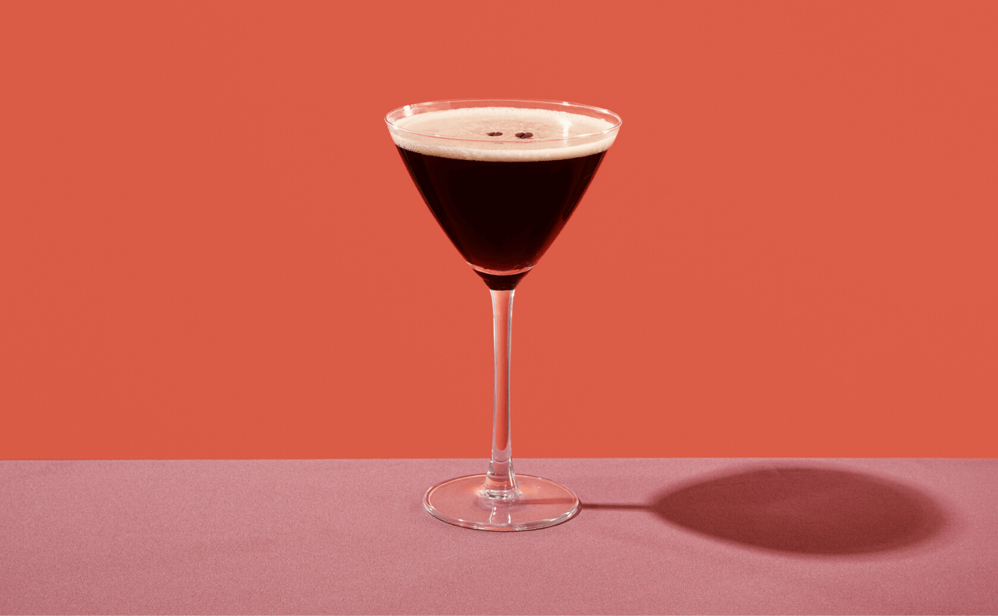 an espresso martini on a pink background