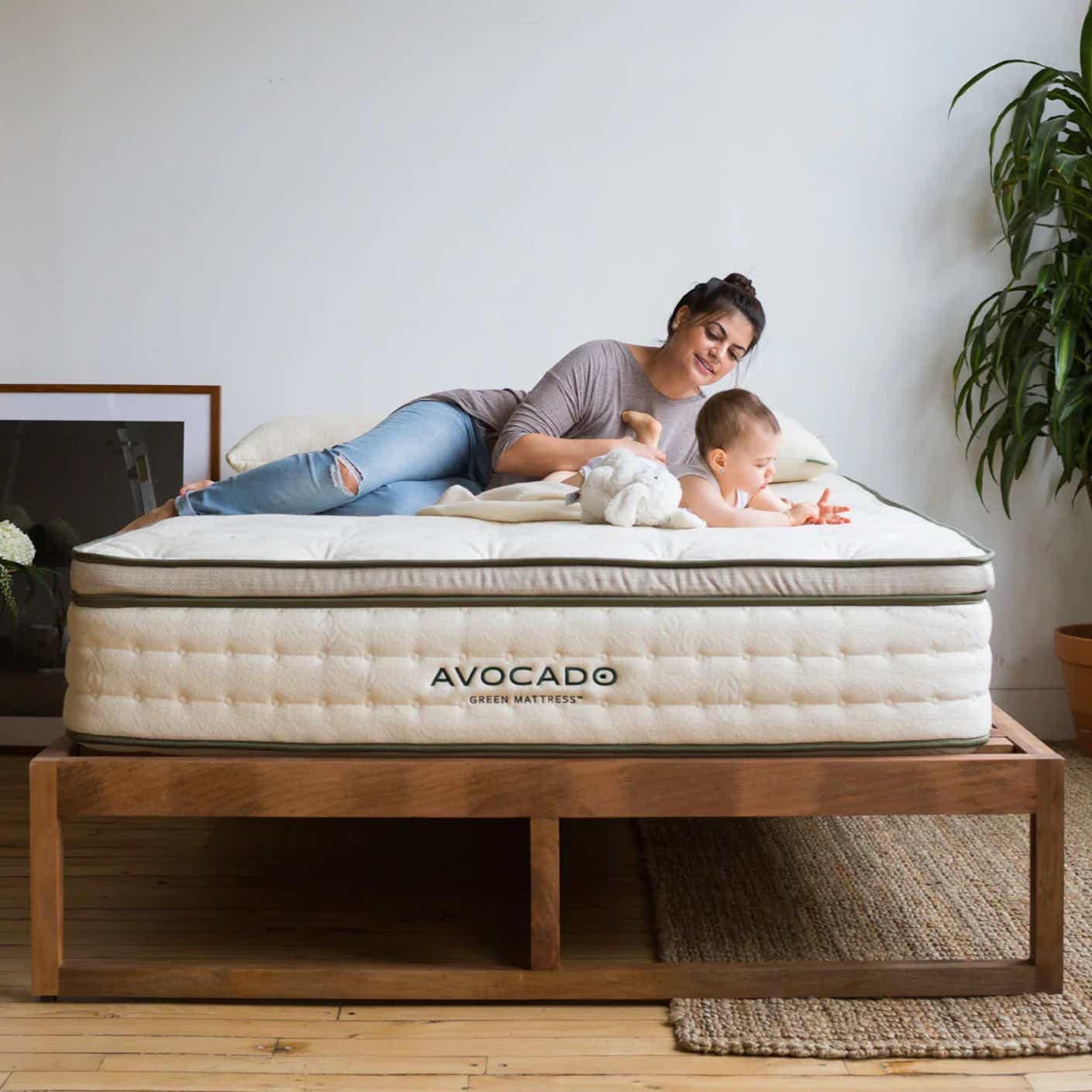 A woman and baby lie on a mattress.