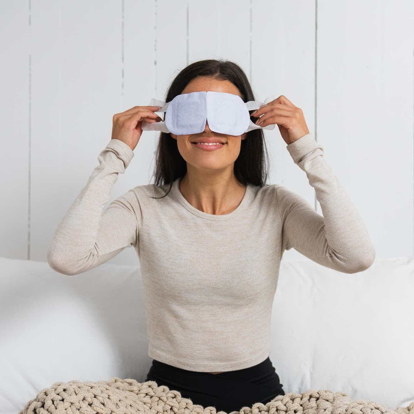 A woman wears a disposable eye mask.