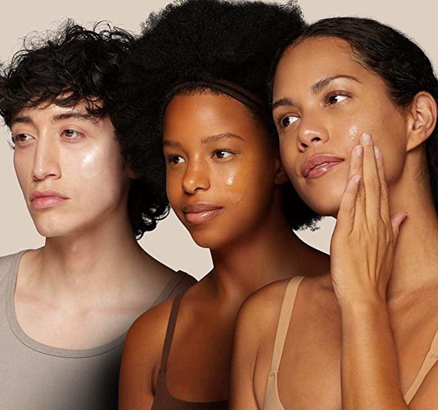Three women pose with facewash on.