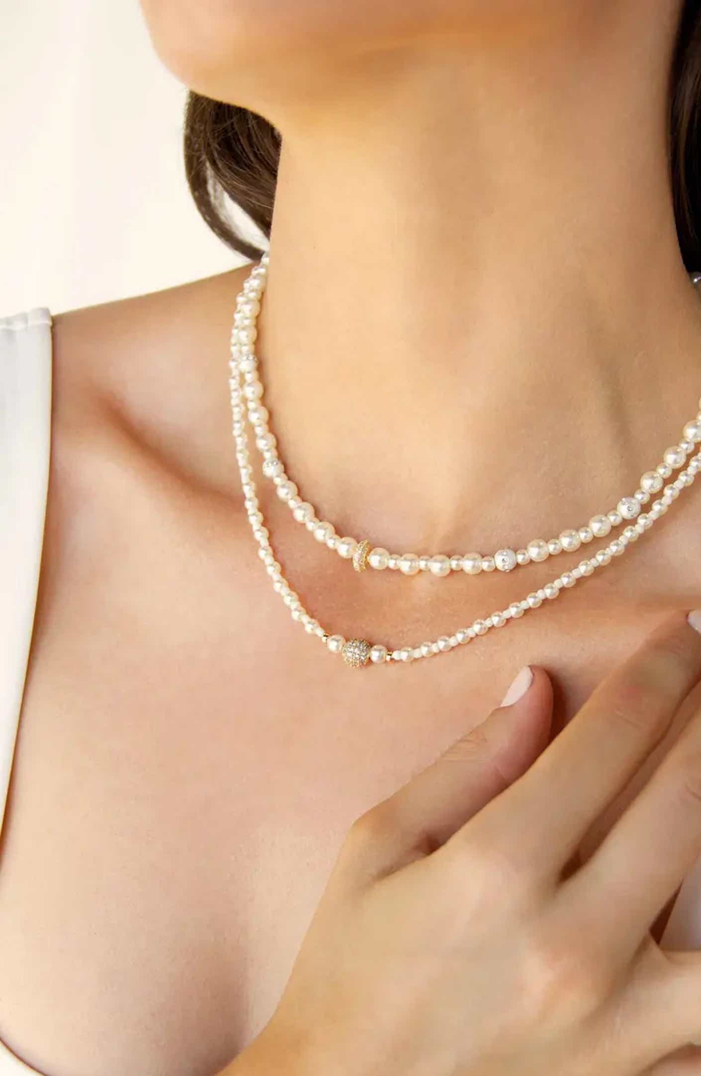A woman wears a pearl necklace.