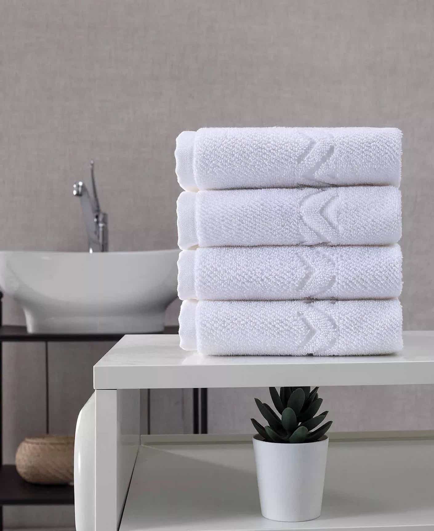 A stack of folded washcloths sit on a bathroom counter.