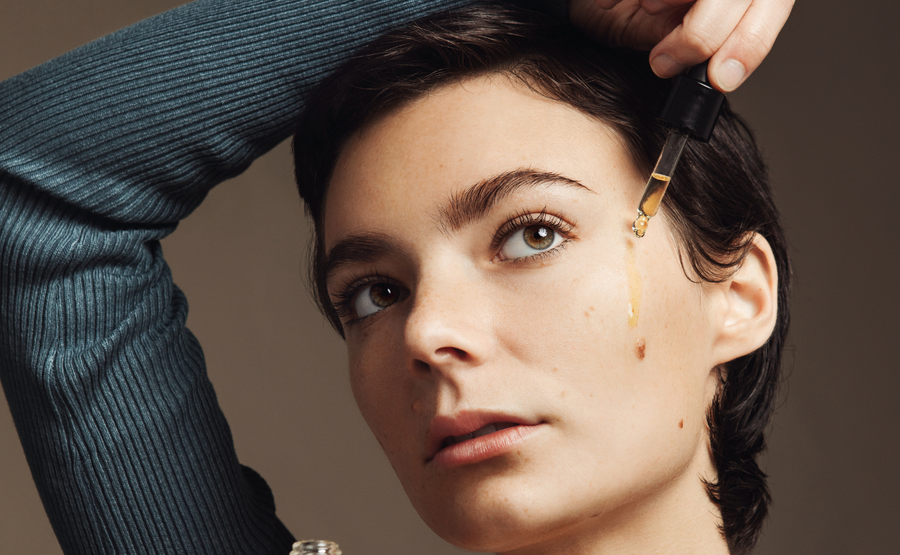 Woman putting Biography face oil on her cheek