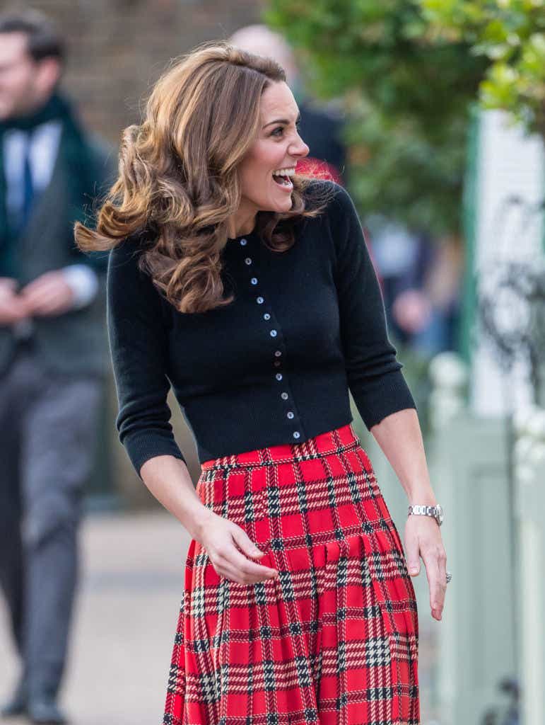 Kate Middleton smiles in black cardigan and gingham skirt