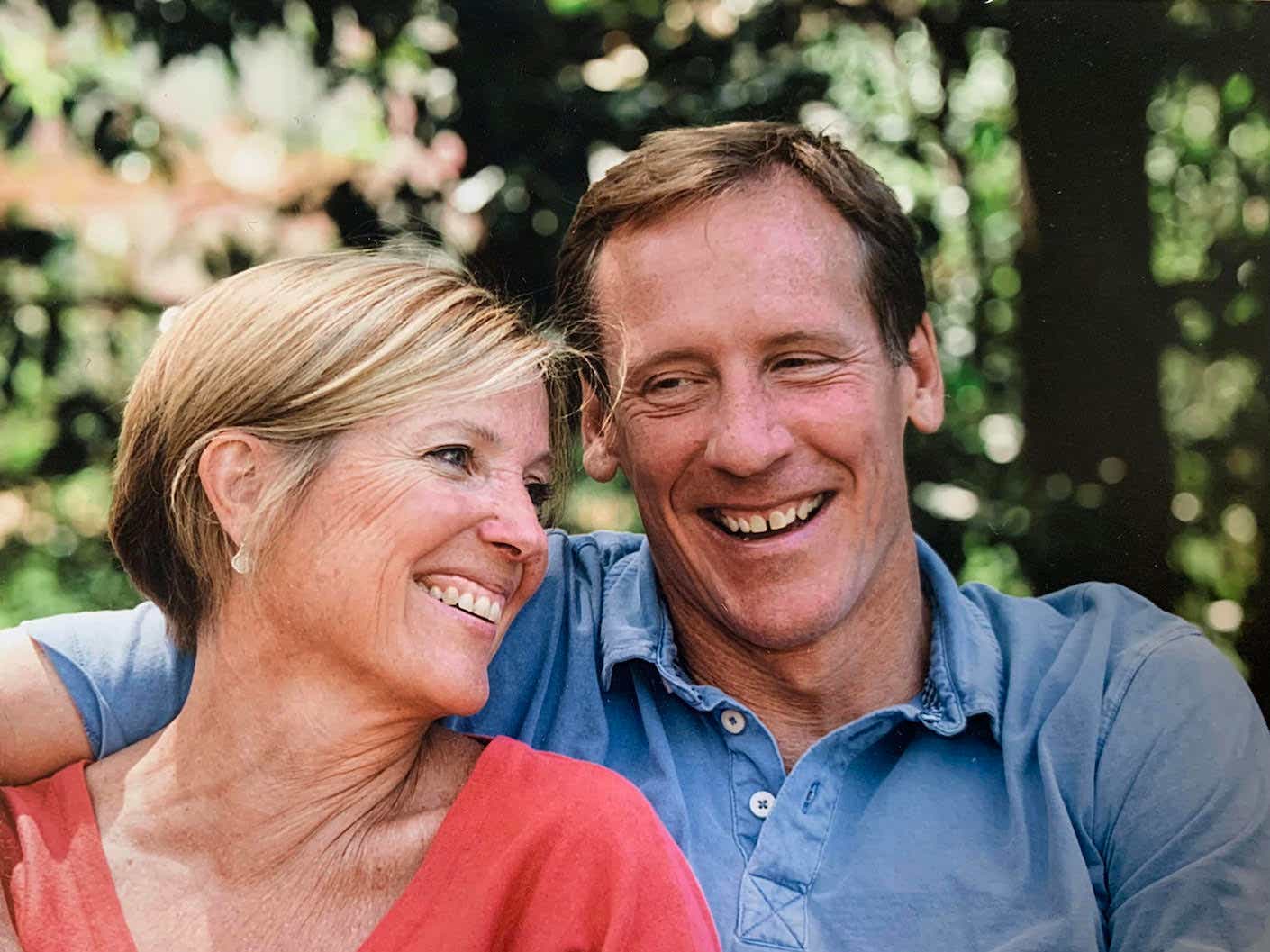 Kathy and her husband smile and pose.