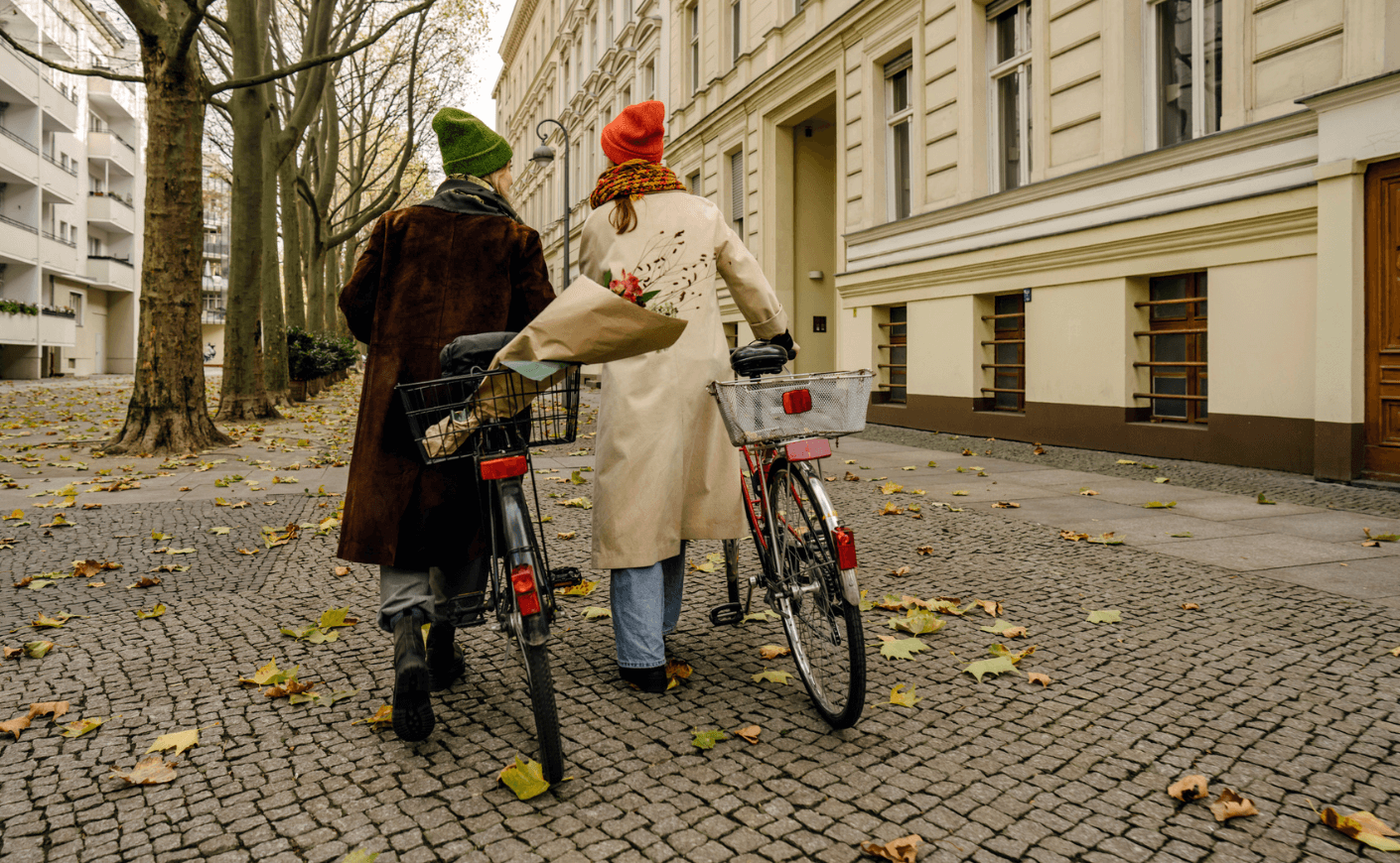 two women walking with bicycles