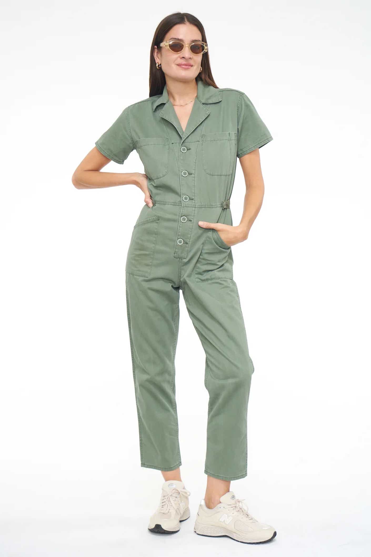 a woman poses in a jumpsuit