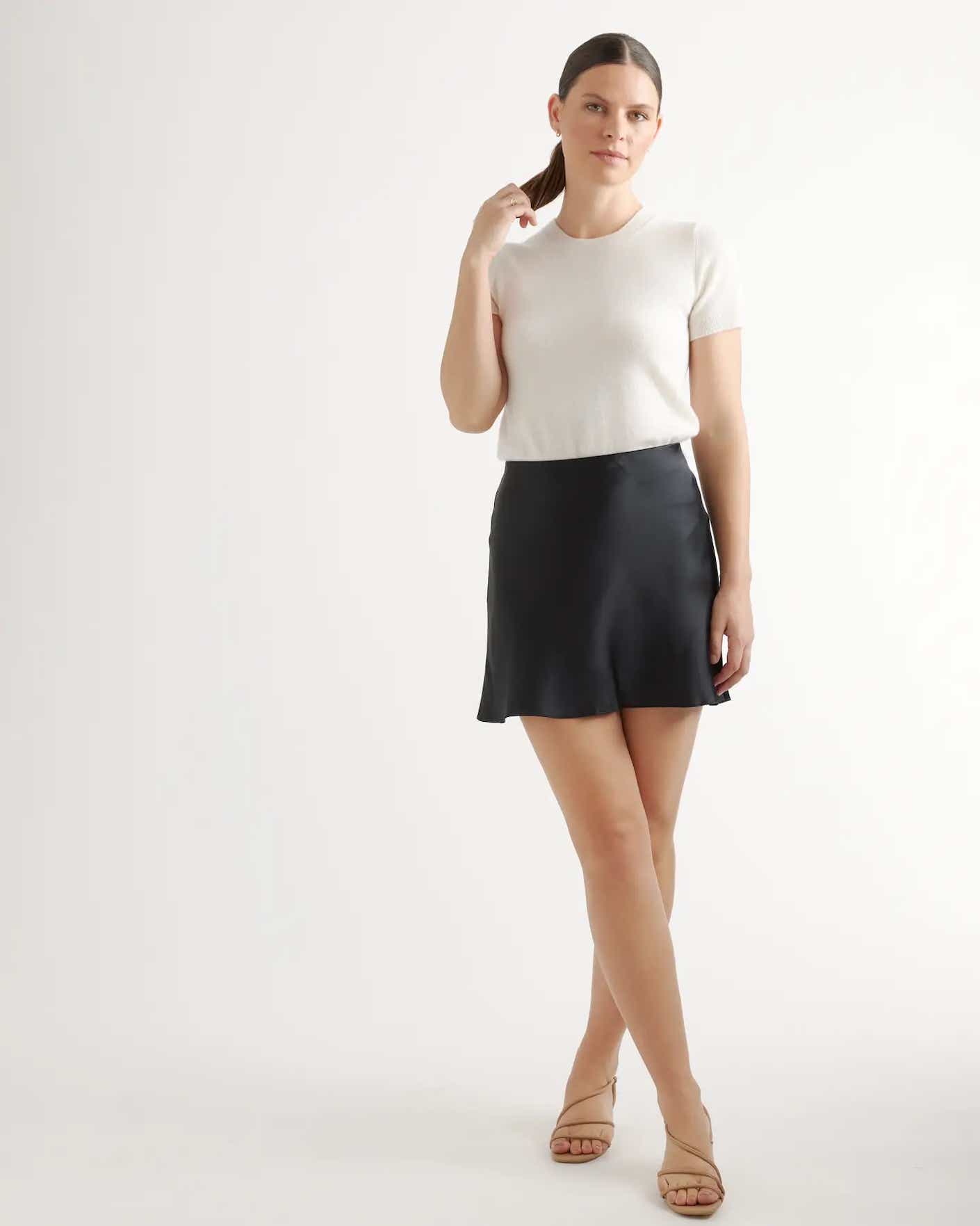 a woman wears a black mini skirt