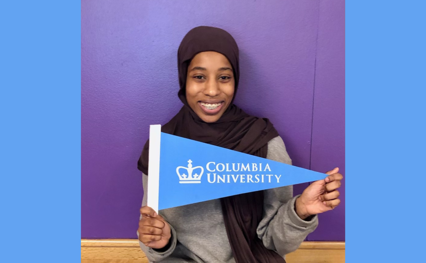 student holding up Columbia University flag