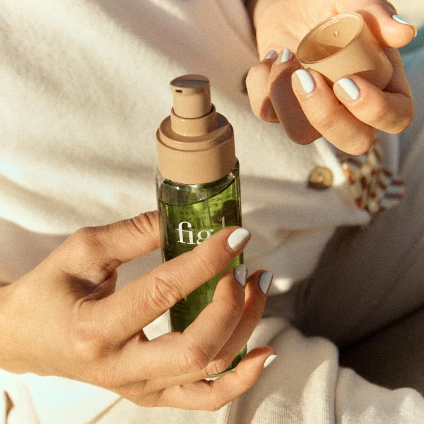 Someone holds a bottle of cleanser in the sunlight