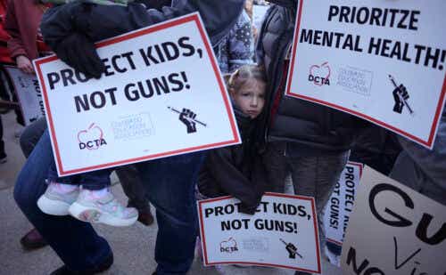 little girl holding up a sign at an anti gun violence protest