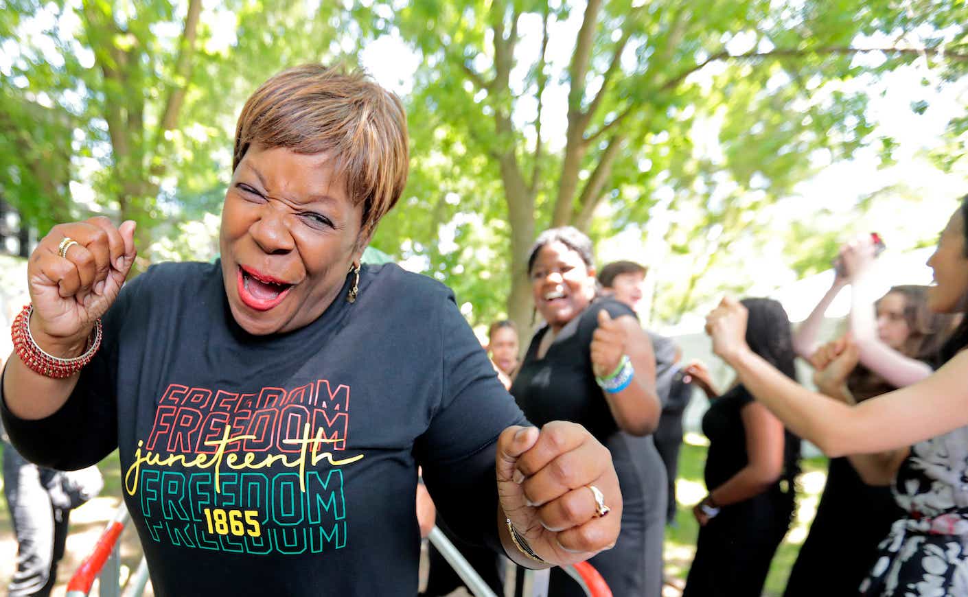 Benita Brown, with The Voices of Embrace, is still pumped after coming off stage, after their performance. The first Juneteenth Concert is held near The Embrace sculpture, on Boston Common.