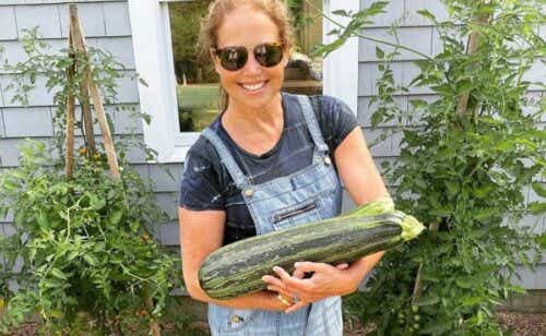 Katie Couric holding a large zucchini