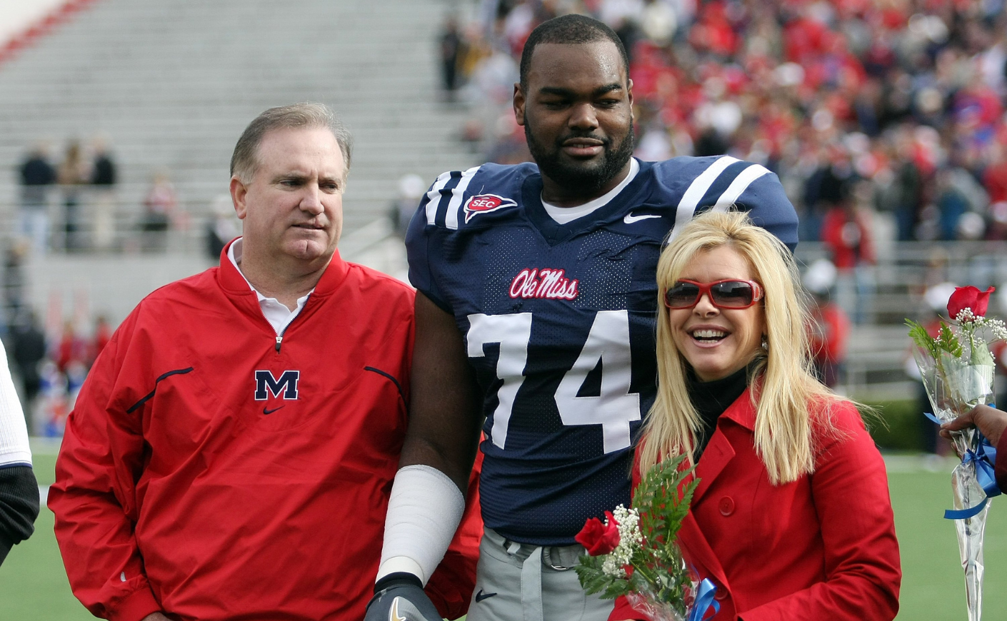 Michael Oher with the Tuohy family on a football field