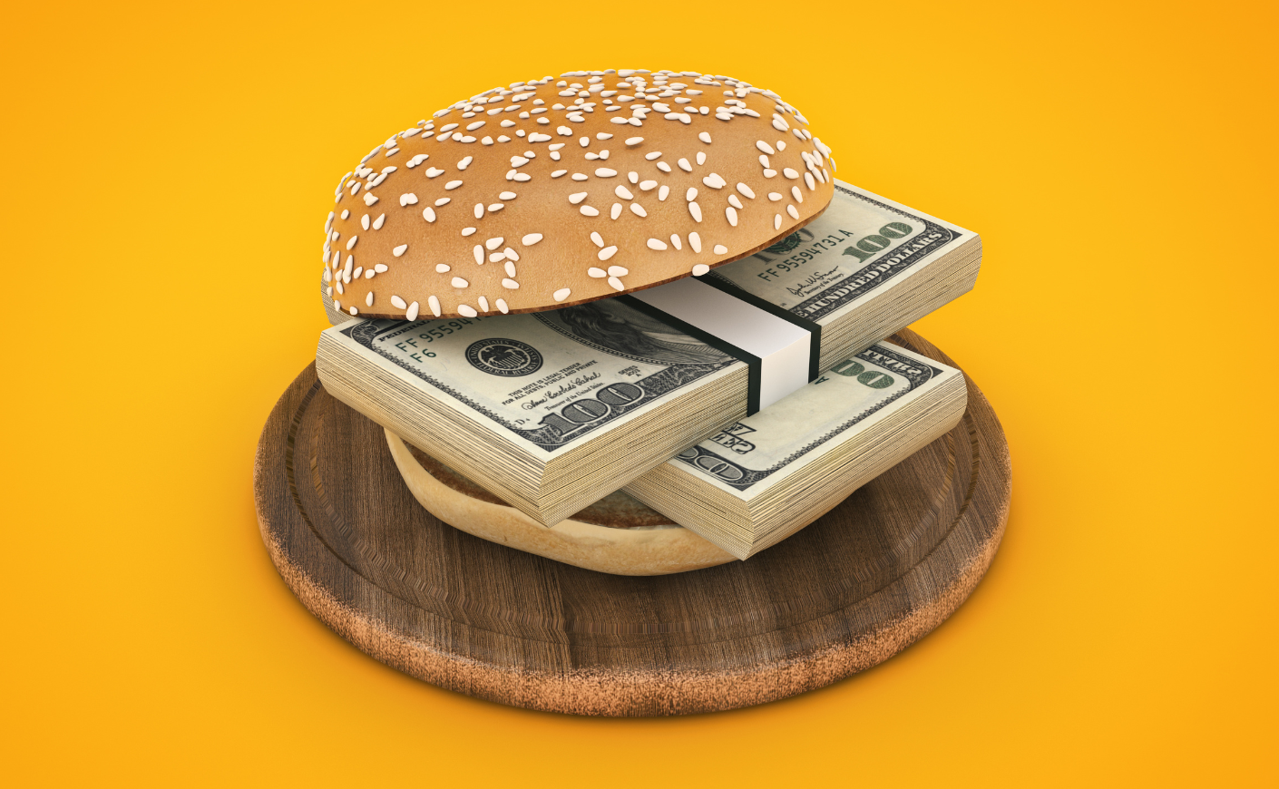 Stacks of $100 bills in between a hamburger bun