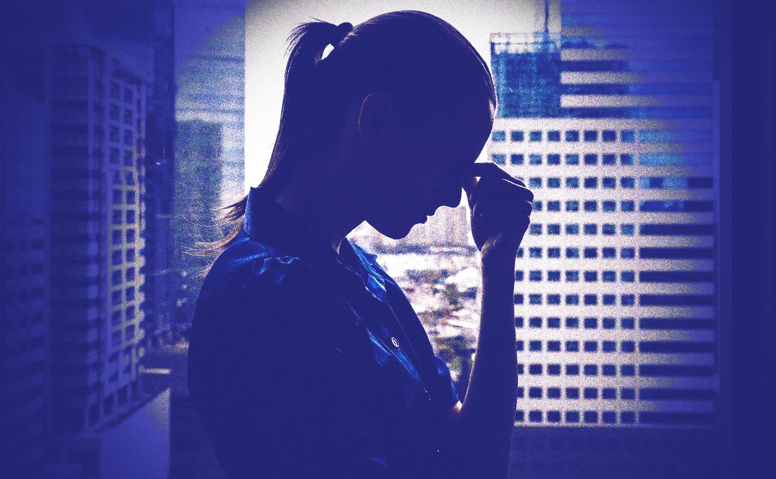 the silhouette of a woman looking distressed in an office