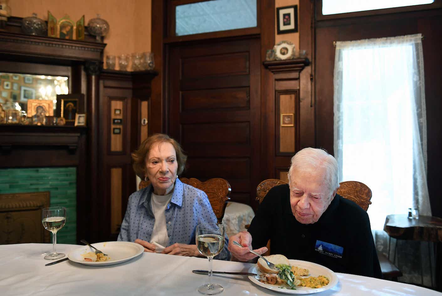 Former President of the United States, Jimmy Carter sits next to his wife, former First Lady, Rosalynn Carter while having dinner at the home of friend, Jill Stuckey