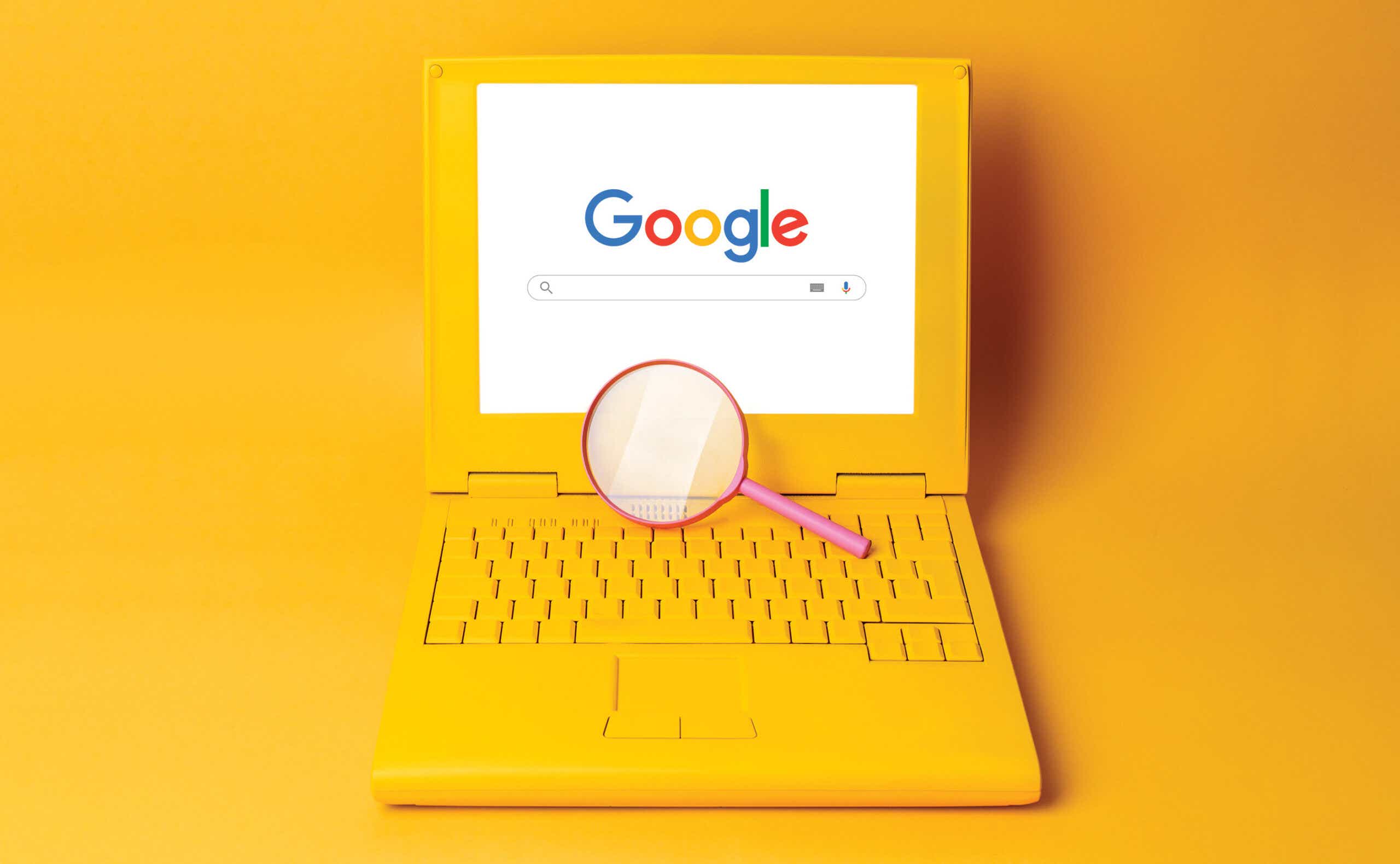 Google search on an orange laptop with a magnifying glass