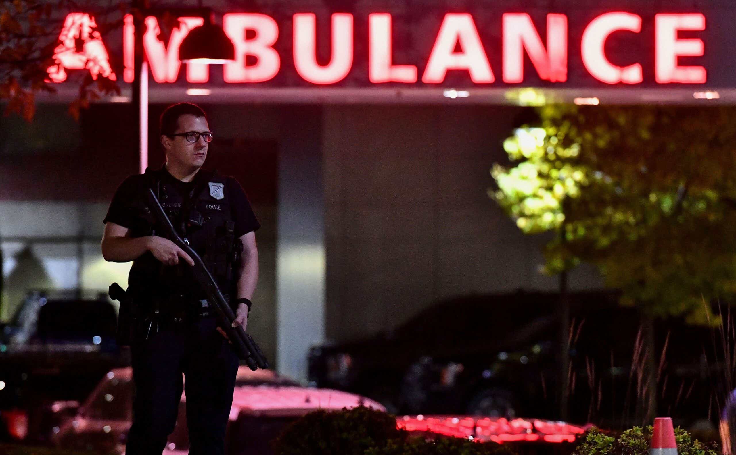 An armed police officer guards the ambulance entrance to the Central Maine Medical Center in Lewiston, Maine