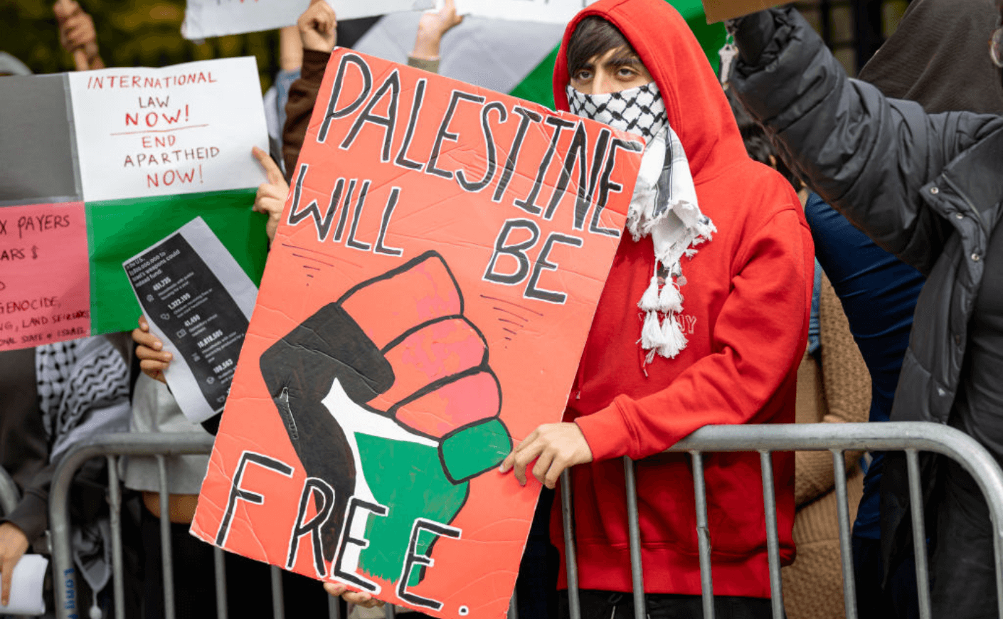 Man at a protest holding a pro-Palestine sign