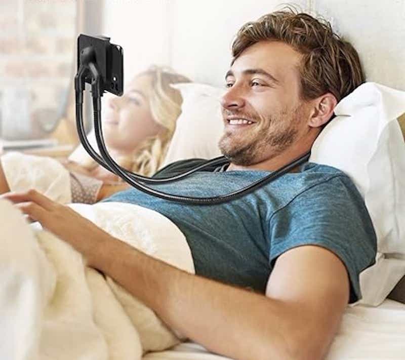 man in bed with an iphone holder around his neck