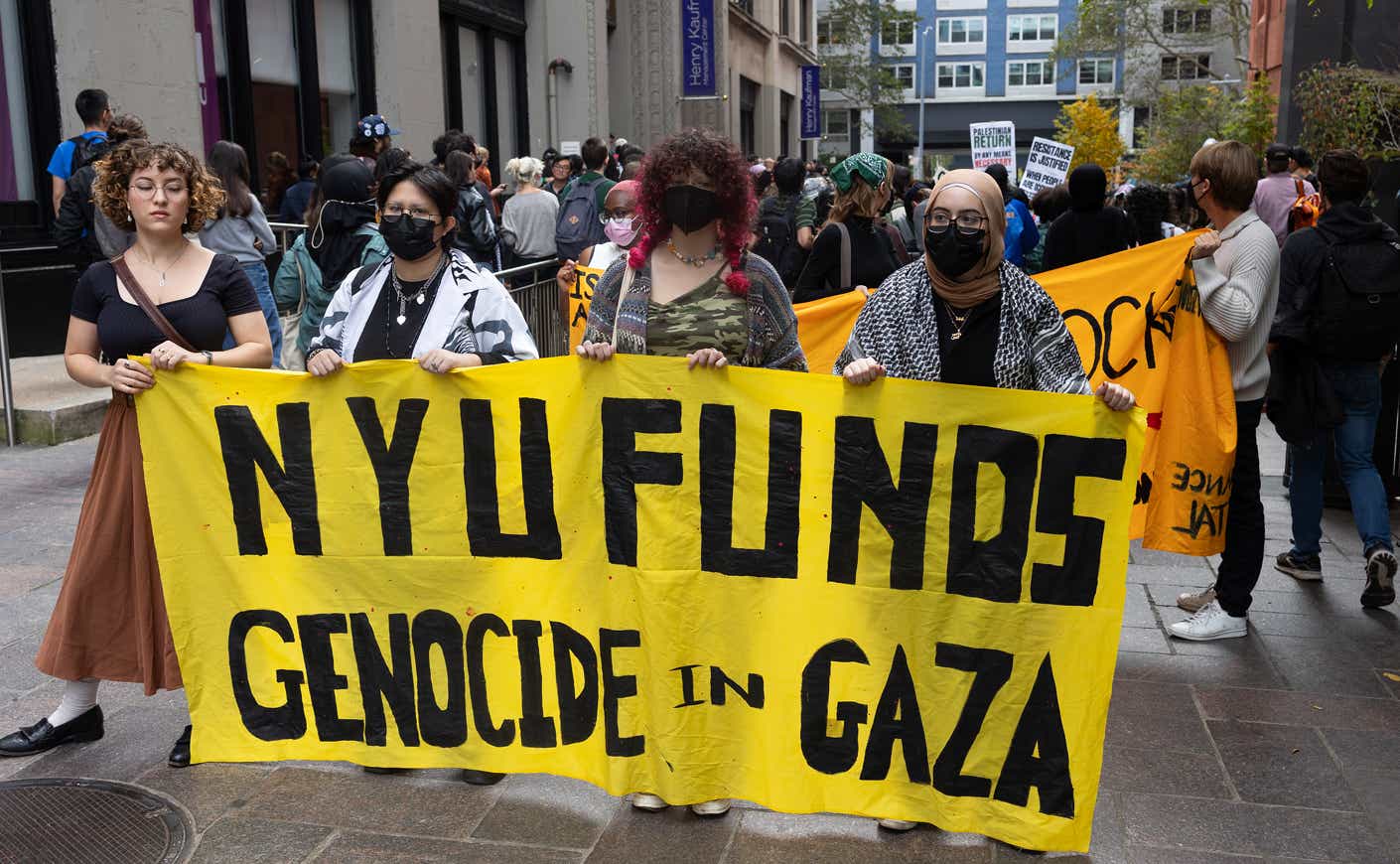 protestors at NYU hold a "NYU finds genocide in Gaza" sign